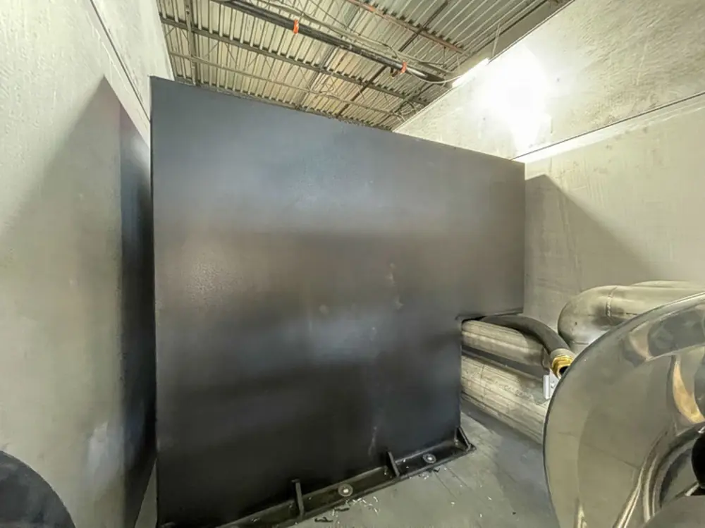 Exterior view of small fire truck showing cab, body compartments, and wheel/tire area.